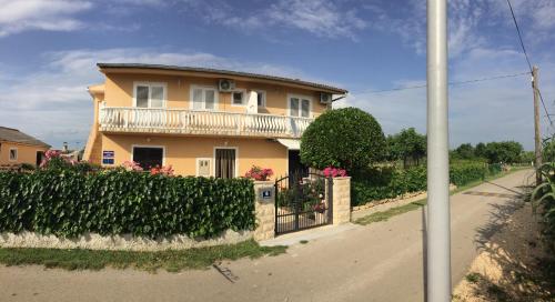 a house with a gate and a fence at Apartments Lolo in Privlaka