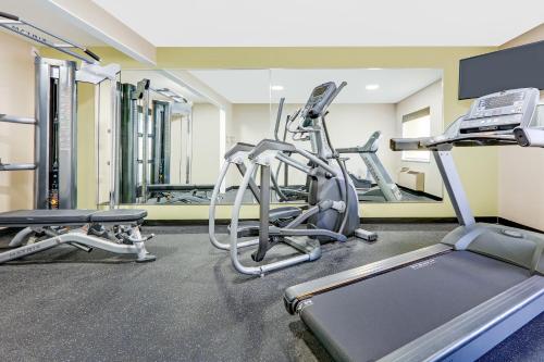 a gym with treadmills and elliptical machines at Baymont by Wyndham Plano in Plano