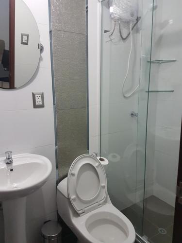 y baño con aseo, lavabo y ducha. en Nino´s Residence Departamentos VIP Amoblados en Tacna