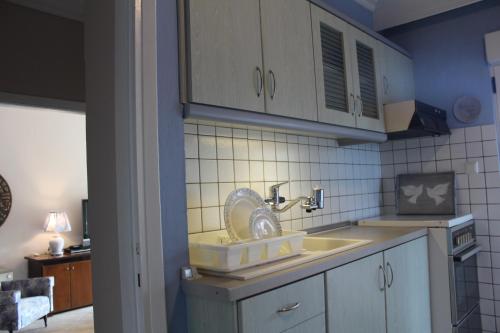 a kitchen with a sink with a fan in it at Balcony By The Sea in Paleo Tsifliki