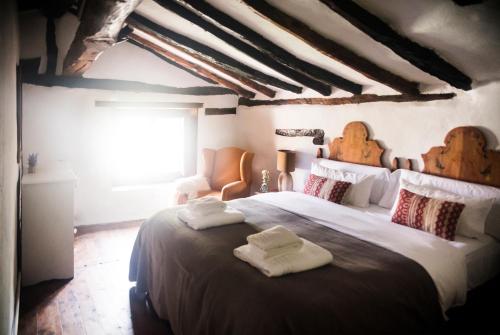 1 dormitorio con 1 cama grande y 2 toallas. en Molino del Feo, en Las Casas Altas