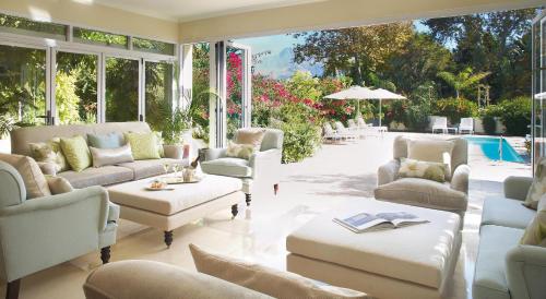 a living room with white furniture and a pool at Last Word Constantia in Cape Town
