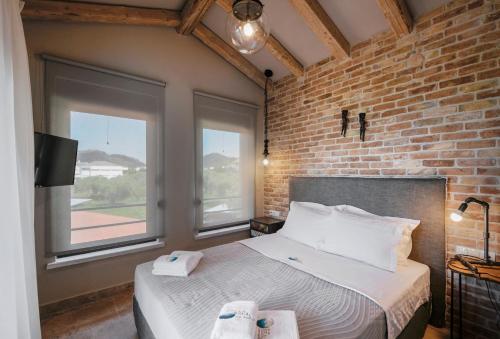 a bedroom with a bed and a brick wall at By the sea luxury suites in Limenas