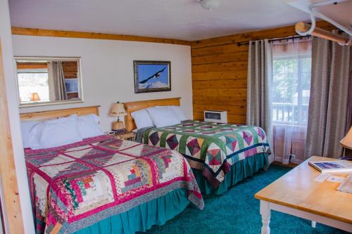 Habitación de hotel con 2 camas y mesa en Homer Floatplane Lodge en Homer