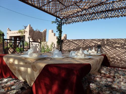 einen Tisch mit Schalen und Platten darüber in der Unterkunft Rose Noire in Ouarzazate