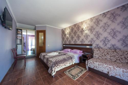 a bedroom with a bed and a couch at Villa Orchidea in Zatoka
