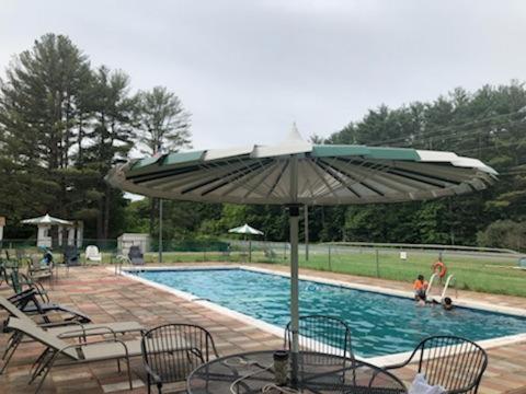 a table with an umbrella next to a swimming pool at Catskill Motor Court in Catskill