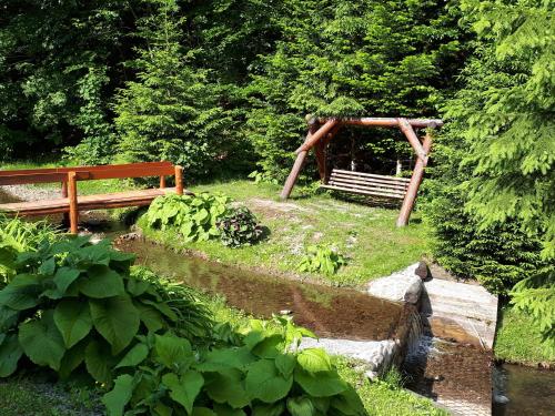 a garden with a wooden bench and a bridge at Apartamenty Kadłubek in Wisła