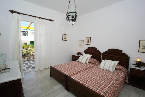 a bedroom with a bed with a red and white blanket at Ostria in Naousa