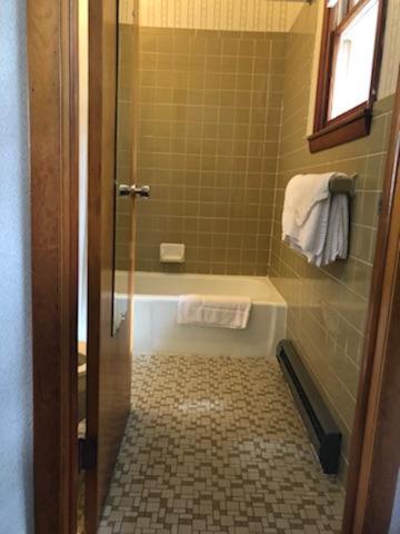 a bathroom with a shower with a tub and a toilet at Catskill Motor Court in Catskill