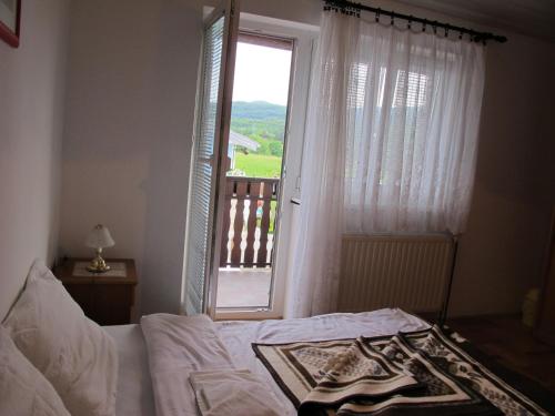 - une chambre avec un lit et une fenêtre avec un balcon dans l'établissement Guesthouse Rupčič, à Grabovac