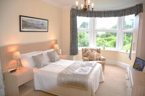 a bedroom with a bed and a chair and a window at White Acre in Scarborough