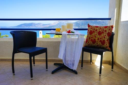 マルマリにあるAlykesのテーブルと椅子2脚、海の景色を望む