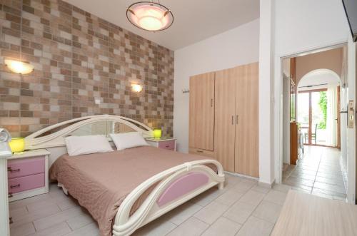 a bedroom with a large bed and a brick wall at Infinity Apartments in Naxos Chora