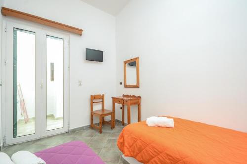 a bedroom with an orange bed and a table at Infinity Apartments in Naxos Chora