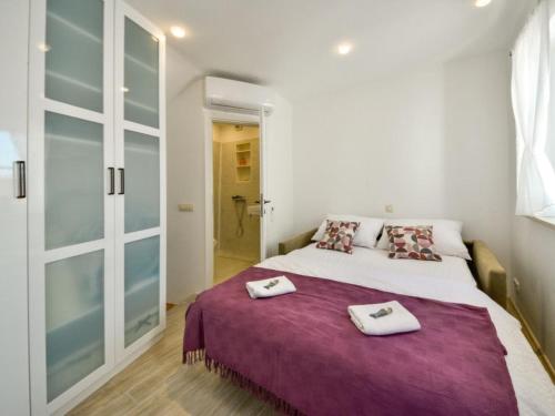 a bedroom with a large bed with two towels on it at Lavender in Baška