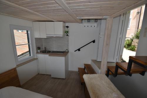 a small kitchen with white cabinets and a table at Lavender in Baška
