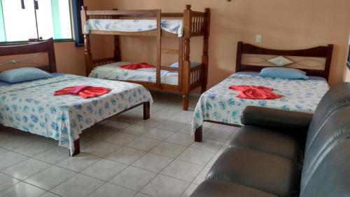 a room with two beds and a bunk bed at Pousada Pesque Park in Boracéia