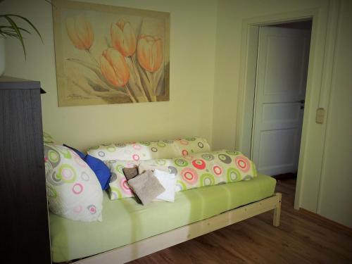 a bedroom with a green couch with pillows and a painting at Grooten Wiebkings in Schneeren
