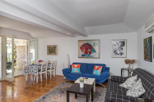 een woonkamer met een blauwe bank en een tafel bij Apartment Dubo in Dubrovnik