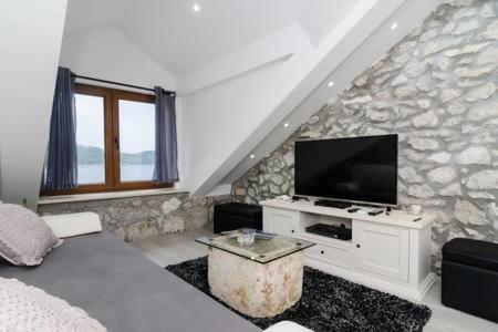 a living room with a bed and a flat screen tv at Apartment Culan in Sobra
