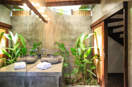 a bathroom with two sinks and some plants at Lua Villas in Santa Teresa Beach