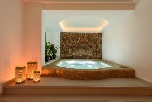 jacuzzi en una habitación con espejo en Antoperla Luxury Hotel & Spa, en Perissa
