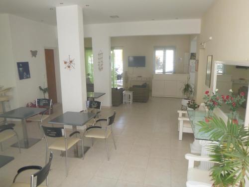 un ristorante con tavoli e sedie in una stanza di Karafelas Hotel a Città di Skiathos