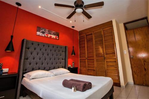 a bedroom with red walls and a bed with a ceiling fan at Casa Blanca Boutique & Organic in Cancún