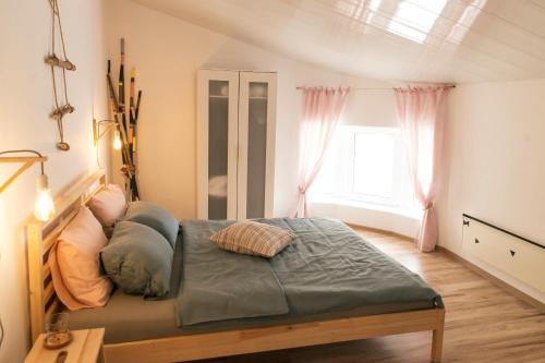a bedroom with a bed and a window at Balabanov White in Varna City