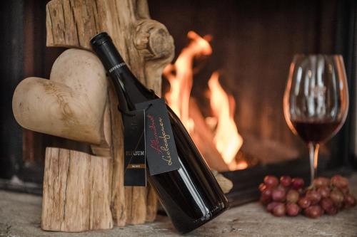 a bottle of wine sitting next to a fire at Hüttendorf Ladizium in Ladis