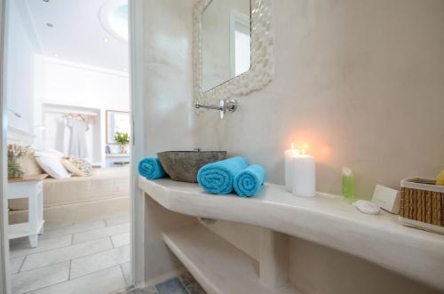 a bathroom with a sink with a candle and a mirror at Naxos Dream Oniro Studios - Adults Only in Naxos Chora
