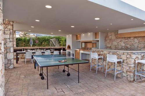 un patio con una mesa de ping pong y un bar en Villa Green Diamond - Private Heated Pool en Platanés