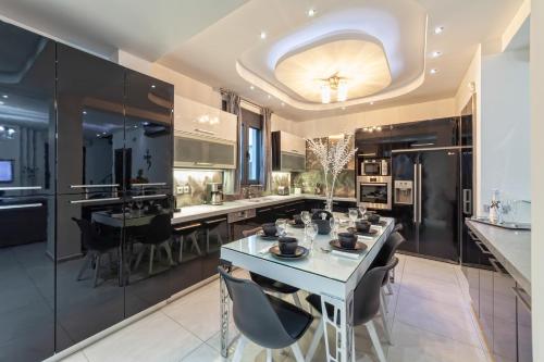 a kitchen with a table and chairs and a counter at Villa Green Diamond - Private Heated Pool in Platanes