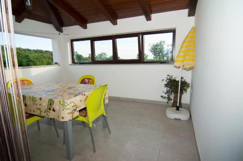 a dining room with a table and chairs and windows at Apartman Garma in Rovinj