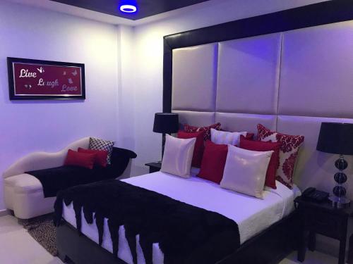 a bedroom with a large bed with red and white pillows at Hotel Rey in Concepción de La Vega