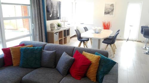 ein Wohnzimmer mit einem blauen Sofa und bunten Kissen in der Unterkunft Appart HautsSarts in Liers