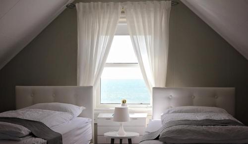 1 dormitorio con 2 camas y ventana en Iðavellir Guesthouse, en Skagaströnd