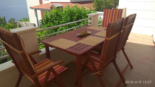 a wooden table and chairs on a balcony at Apartments Niana with heated swimingpool in Okrug Donji