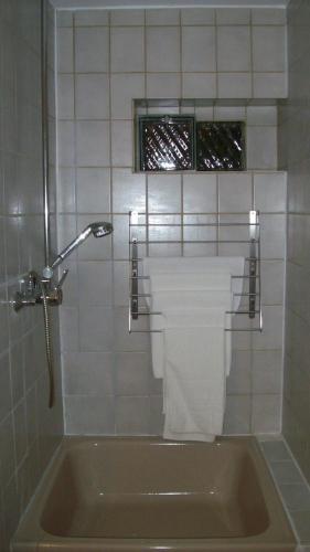 a bathroom with a tub and a toilet and a window at Dormitorium Kaarst Wohnraum auf Zeit in Kaarst