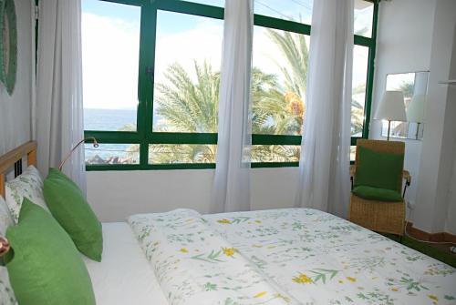 a bedroom with a bed and a large window at Ocean Breeze Alcalá in Alcalá