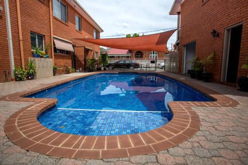 a blue pool sitting in front of a brick building at Meramie Motor Inn in Albury