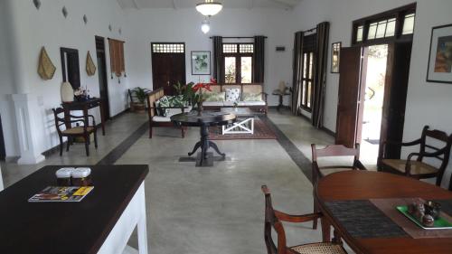 a living room with a table and chairs at Strathisla Tea Estate Bungalow in Matale