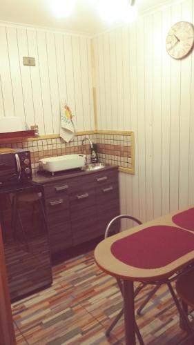a kitchen with a table and a clock on the wall at Cabañas Avenida España in Punta Arenas