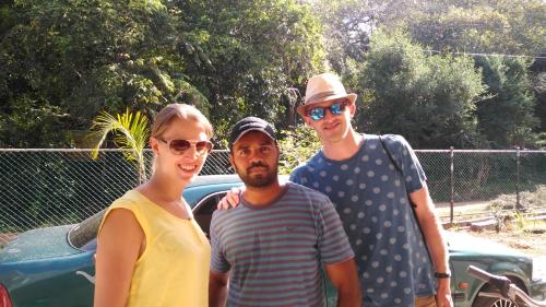 a group of three people standing next to a car at Priyanna Guest, Forest view in Polonnaruwa