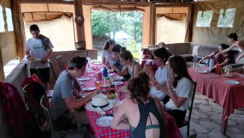 a group of people sitting around a table in a tent at Oldarpoi Wageni Camps in Keekorok