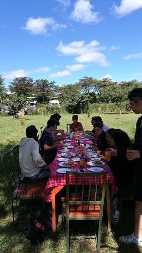 a group of people sitting around a picnic table at Oldarpoi Wageni Camps in Keekorok