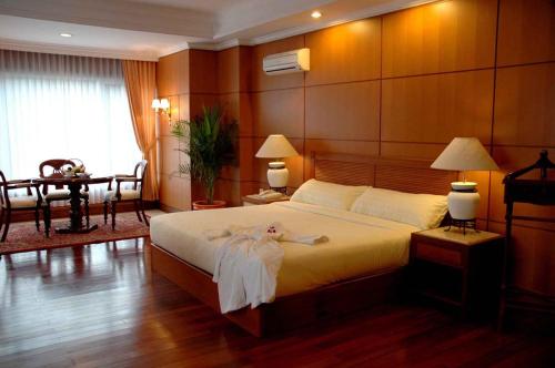 a bedroom with a bed with a dress on it at Royal Senyiur Hotel in Prigen
