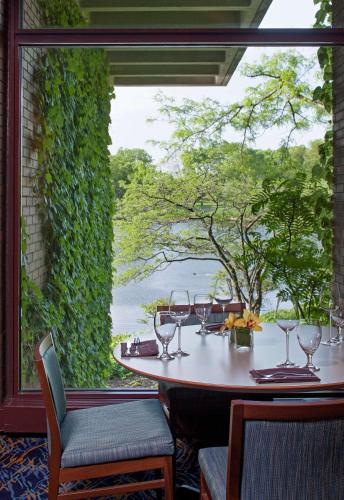 a table with wine glasses and a view of the water at Hyatt Lodge Oak Brook Chicago in Oak Brook