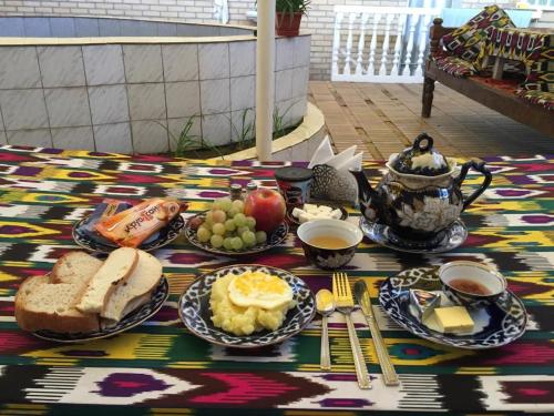 a table with a breakfast of eggs and bread and coffee at Timur The Great in Samarkand